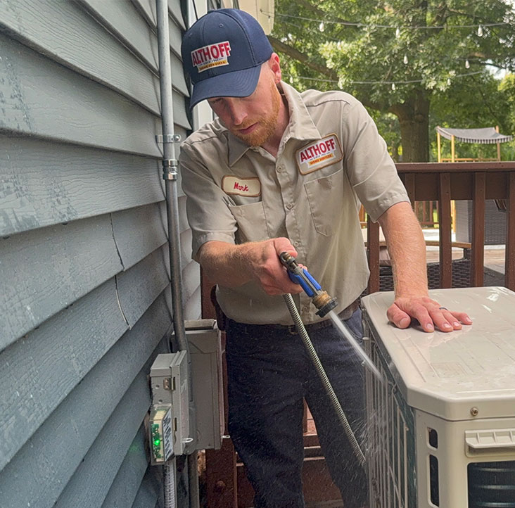 technician working on a residential ac unit outside